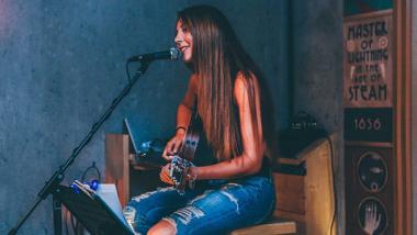 Singing Girl with Guitar in Blue Room